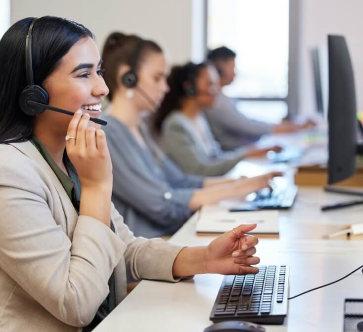A line of call center agents working with customers, speaking into headsets - coolest call center in Tijuana.