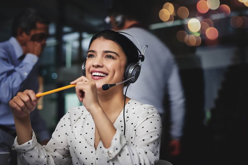 Cropped shot of an attractive young woman looking thoughtful and smiling while working in a call center in Tijuana.