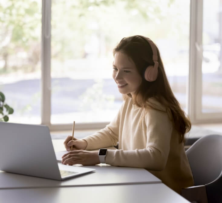 Girl wearing headphones using laptop in call center, improve foreign language skills, gain new knowledge online.
