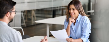 Smiling professional female HR having job interview meeting with male recruit to work in the best call center job in Tijuana.
