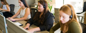 Three call center employees work side by side in the best call center in Tijuana.
