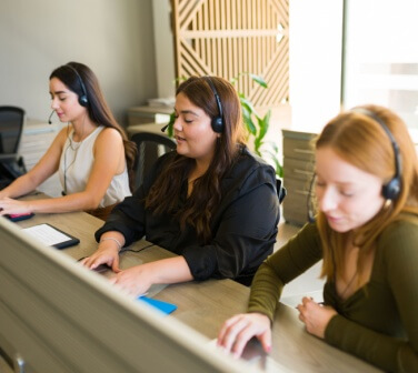 Three call center employees work side by side in the best call center in Tijuana.