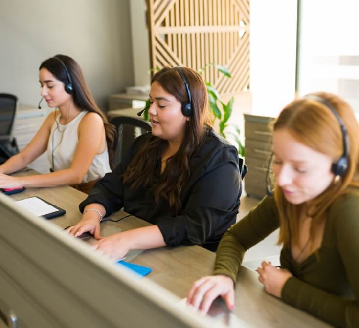 Three call center employees work side by side in the best call center in Tijuana.