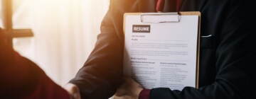 Close up view of job interview in office, focus on resume writing tips, employer reviewing good cv of prepared skilled applicant, recruiter considering application, HR manager making hiring decision for best call center in Tijuana.