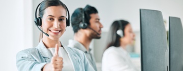 Female call center agent gives thumbs up to the benefits of working in a fast-paced environment.