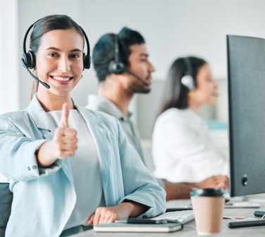 Female call center agent gives thumbs up to the benefits of working in a fast-paced environment.