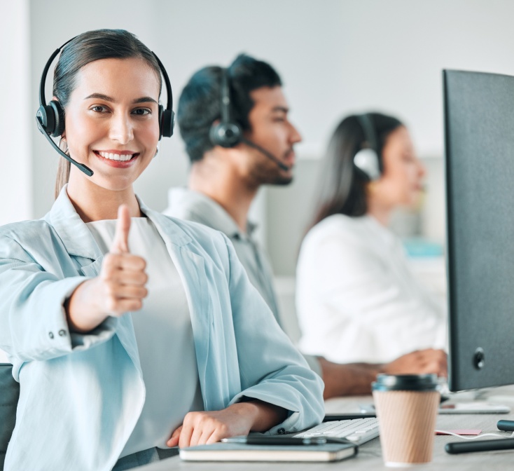Female call center agent gives thumbs up to the benefits of working in a fast-paced environment.