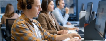 Diverse group of young professionals working and training at a call center.