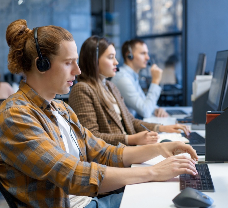Diverse group of young professionals working and training at a call center.