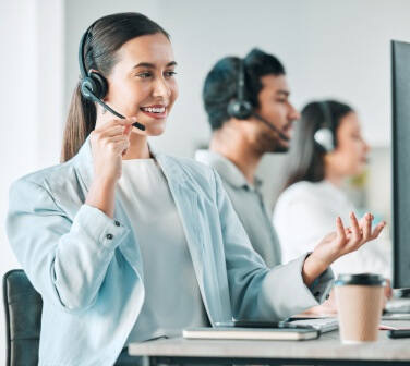 A woman agent with problem-solving skills in call center jobs, smiling as she attends to a customer.