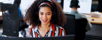 Woman with computer at call center for customer support, information and script enjoying cultural benefits of nearshore call centers.