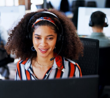 Woman with computer at call center for customer support, information and script enjoying cultural benefits of nearshore call centers.