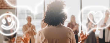 Woman presenting to a group, backlit by sunlight. Diverse audience clapping. Engaging presentation, teamwork, and communication highlighted. Business call center leadership skills.