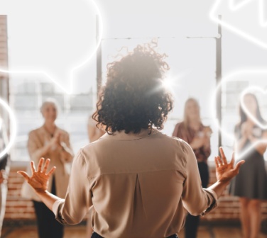 Woman presenting to a group, backlit by sunlight. Diverse audience clapping. Engaging presentation, teamwork, and communication highlighted. Business call center leadership skills.