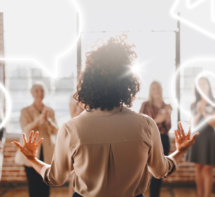 Woman presenting to a group, backlit by sunlight. Diverse audience clapping. Engaging presentation, teamwork, and communication highlighted. Business call center leadership skills.