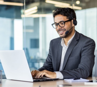 A professional call center agent working on a laptop with a headset, representing call center global careers in an international business environment-1