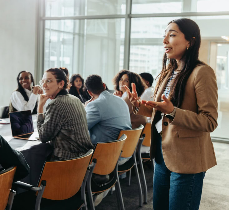 A confident female leader engages a diverse team in a professional workshop, promoting teamwork and fresh ideas in a bright office environment with her call center leadership skills.