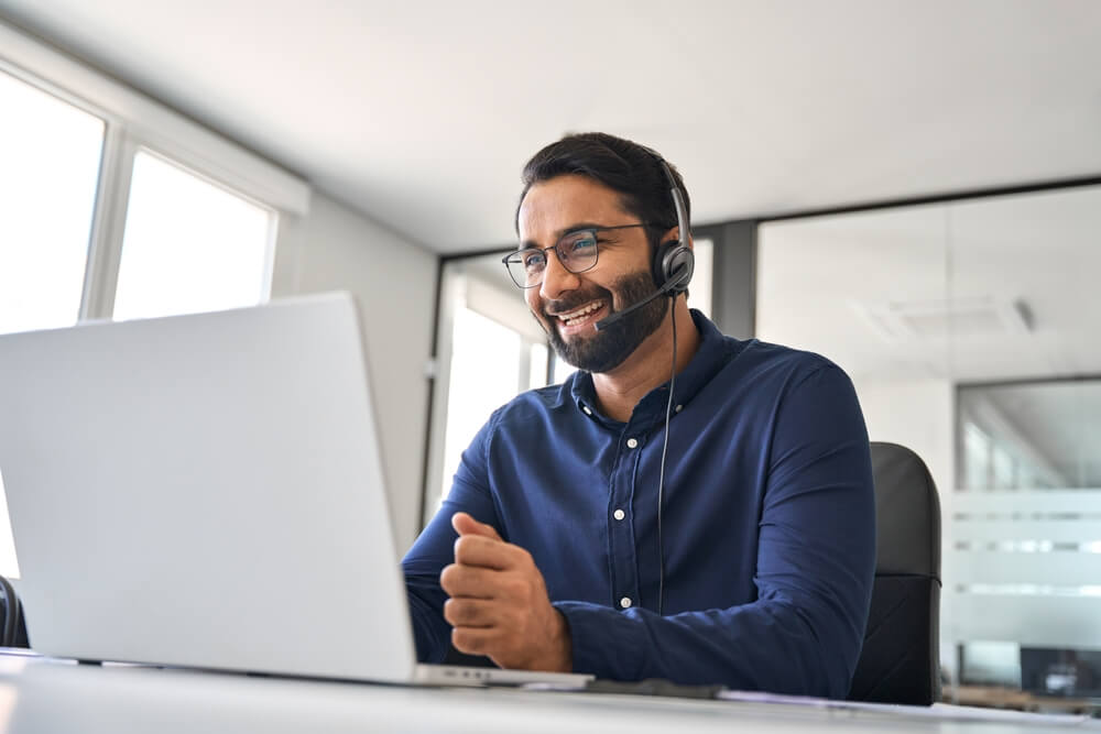 Customer service representative assisting a client on a laptop, representing support through call centers.