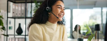 Smiling agent wearing a headset in an office, illustrating friendly service in call centers-1