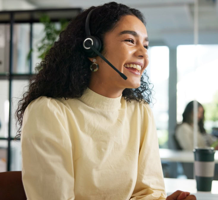 Team leader assisting customer support agents wearing headsets in a modern office, illustrating teamwork and training in nearshore call center jobs.
