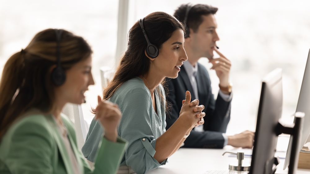 Support team members listening to customers and handling feedback professionally during a busy service environment.