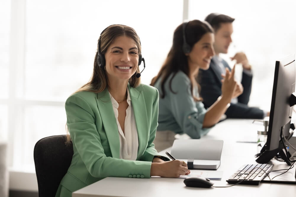Smiling call center agent wearing a headset while building confidence as a new call center agent.