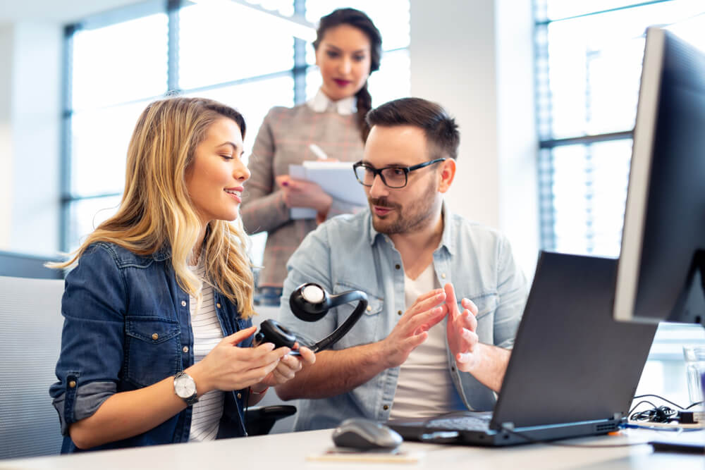 Call center team members collaborating during a coaching session, demonstrating training, peer support, and communication strategies that help prevent burnout in customer service environments.
