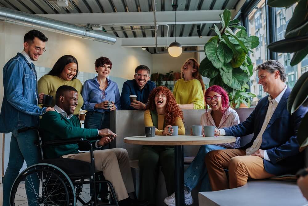 Diverse call center team enjoying a relaxed break together, illustrating how positive workplace culture, inclusion, and social connection can help avoid burnout and improve employee well-being.