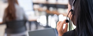 Call center agent wearing a headset while supporting the customer journey.