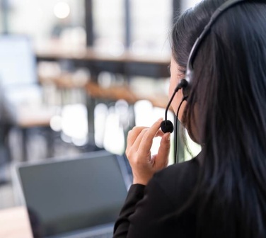 Call center agent wearing a headset while supporting the customer journey.