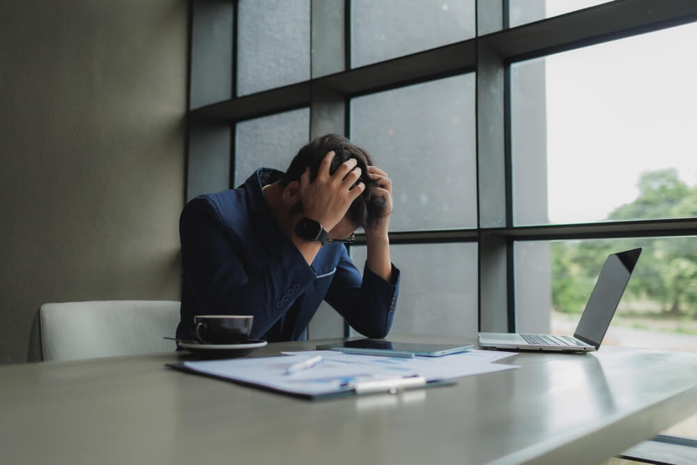 Stressed employee sitting at his desk after a demanding work shift.