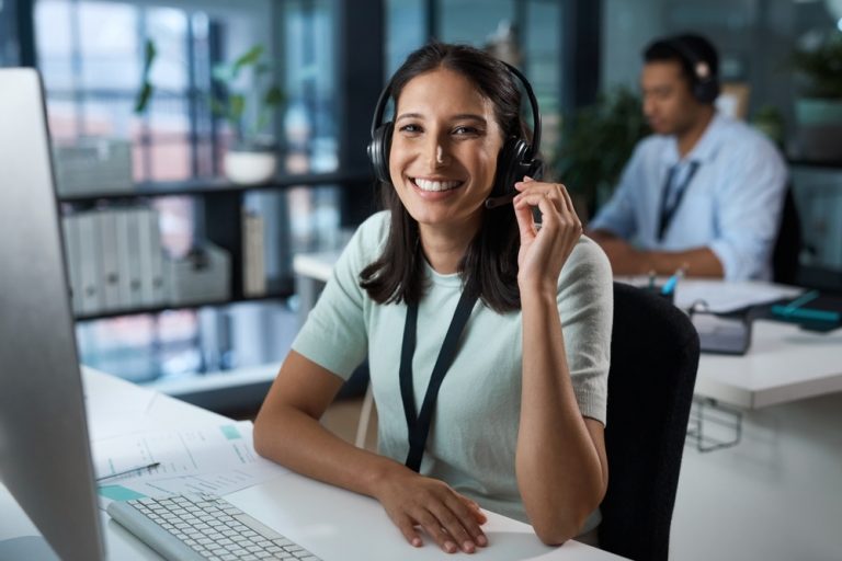 Asesora con audífonos trabajando en un call center 