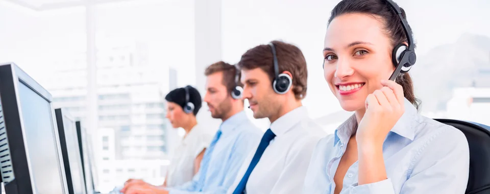 Asesores de call center trabajando con audífonos frente a sus computadoras