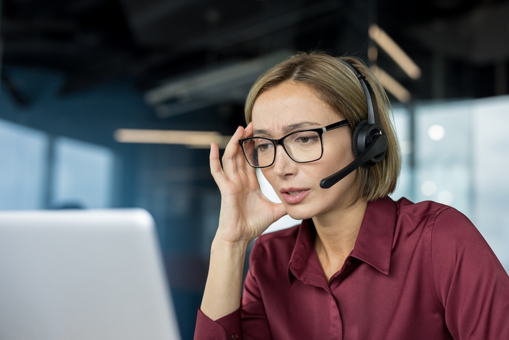 Agente con audífonos aplica inteligencia emocional para atender clientes difíciles durante una llamada.