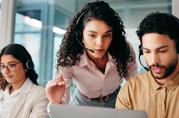 Equipo de call center colaborando durante una llamada y poniendo en práctica habilidades útiles para cualquier profesión.