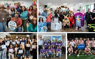 Un grupo de compañeros de trabajo disfrazados posa en una oficina decorada para una celebración temática.