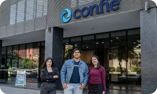 Tres empleados están de pie frente a la entrada de una oficina de Confie.