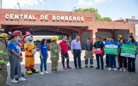 Confie employees with firefighters and mascots, standing in front of the Central Fire Station.