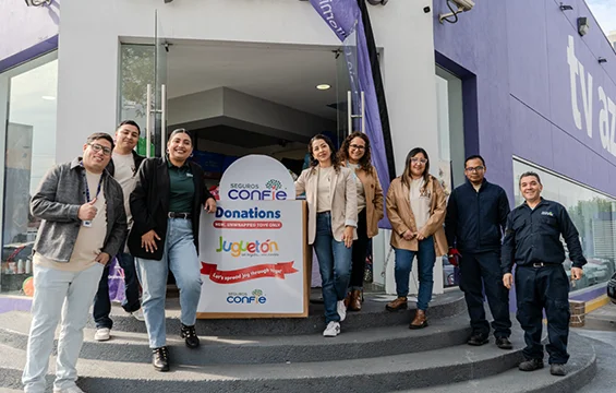 Seguros Confie employees waving outside TV Azteca on the day of the toy donation delivery.