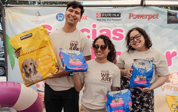 Seguros Confie team members at Croquetón Tijuana 2025 holding bags of dog and cat food to support local animal shelters.