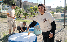 A Confie employee helps restore Santa Fe Park by repainting recreational areas during a community volunteer event in Tijuana.
