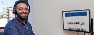 Young agent inside his office with a computer in the background.