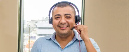 Happy male agent holding his headset.