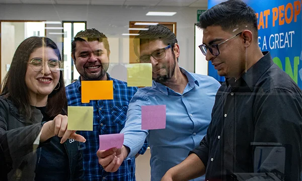 Group of coworkers reading sticky notes.