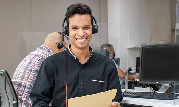 Young customer service agent holding a folder while smiling.