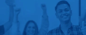 Four young happy people in a call center raising their hands.