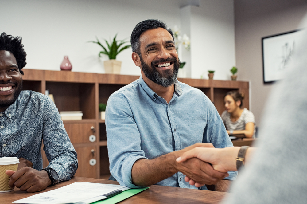 hispanic business man shaking hand and smiling